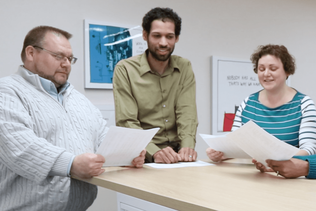 Three Hajoca employees standing at a table reviewing documents