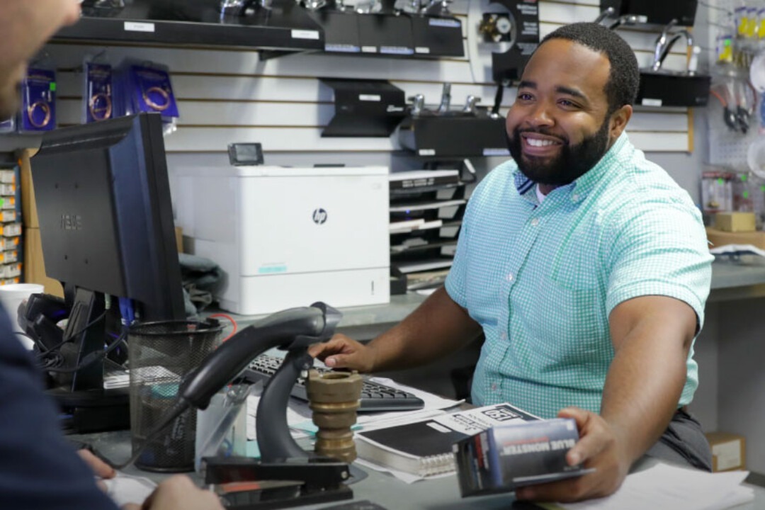 Smiling Hajoca teammate working the register at a sales counter