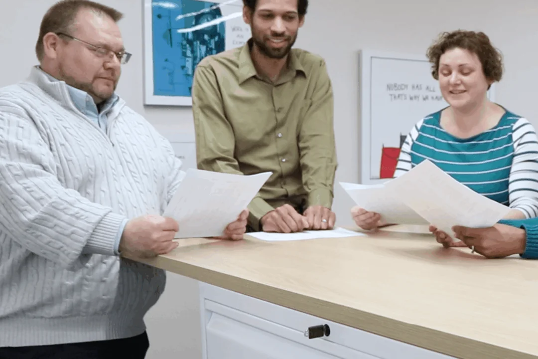 Three Hajoca employees standing at a table reviewing documents